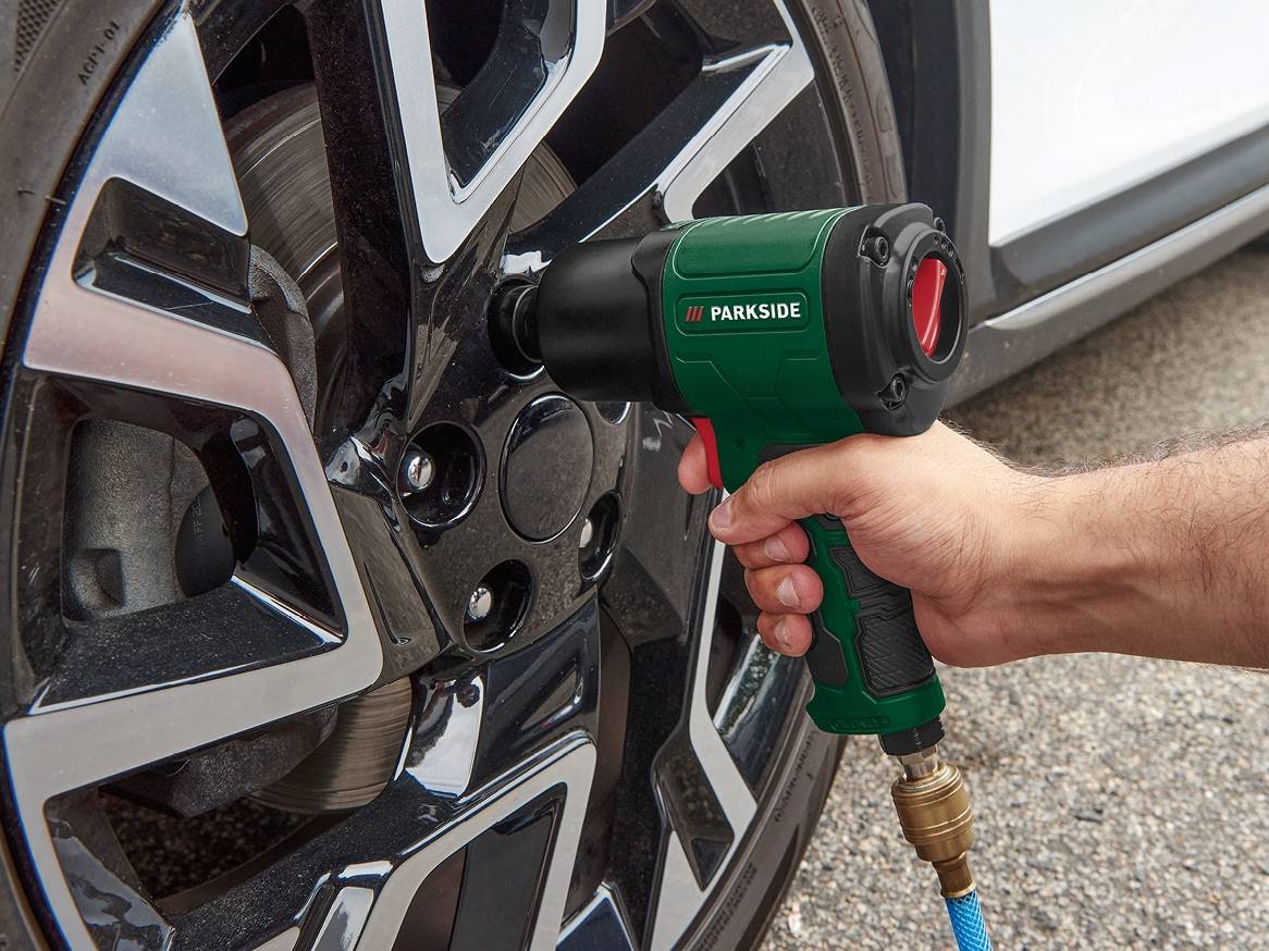 Muž používá pneumatický utahovák Parkside k výměně kola automobilu.