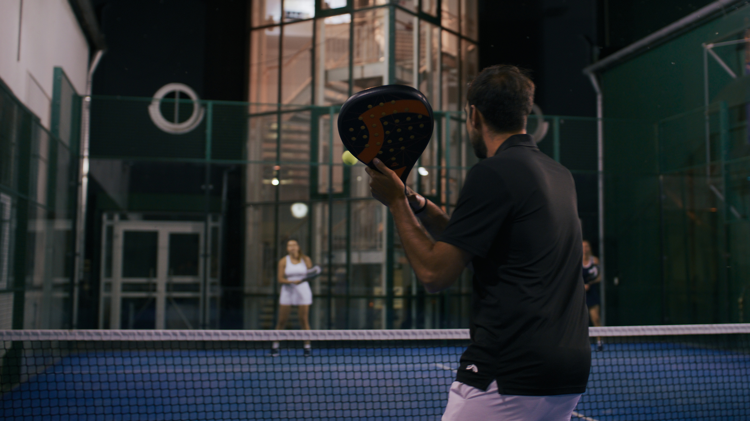 Padeltenis: hráč s raketou, noční zápas.